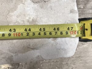 A close-up view of a measuring tape placed against a stone.